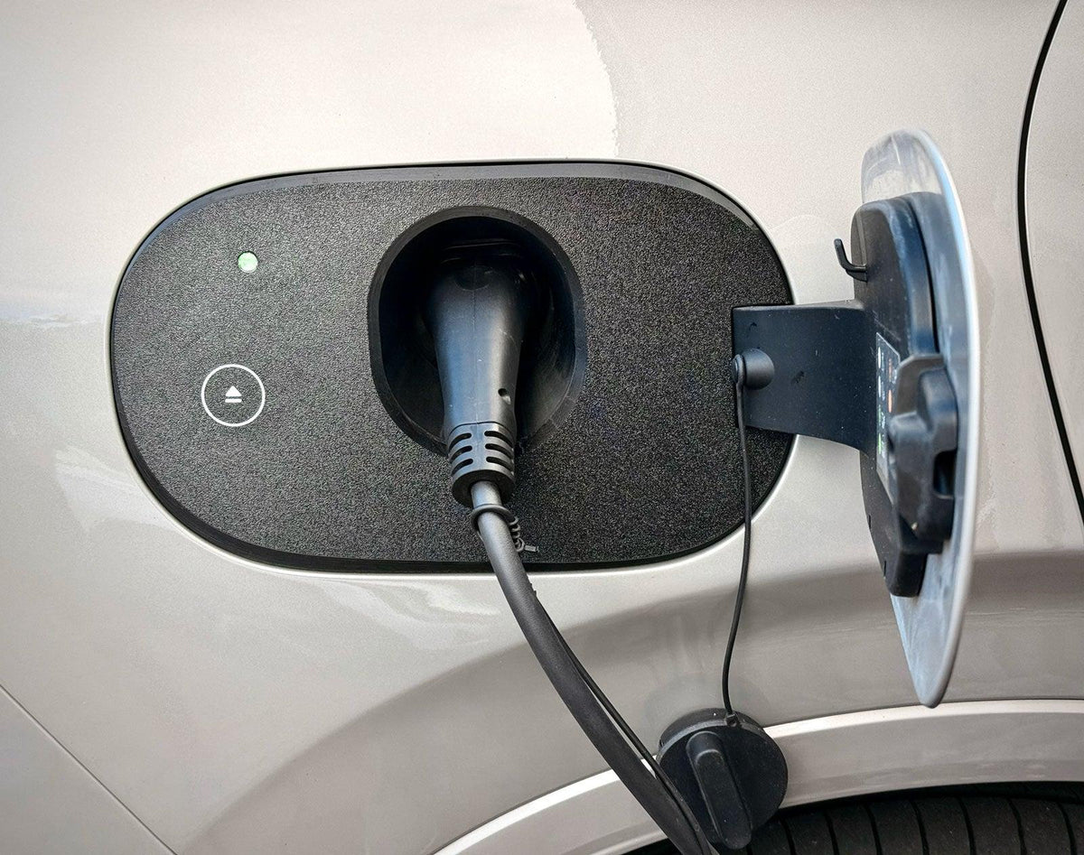 Mazda CX-60 Hybrid Ladeport Cover tæt på med eject-symbol, grøn ladelampe og tilsluttet ladekabel
