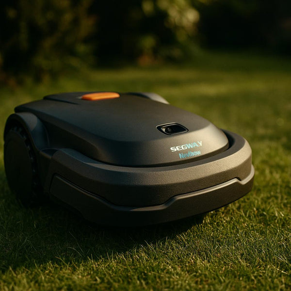 Plænerobot i græsset under solskin.