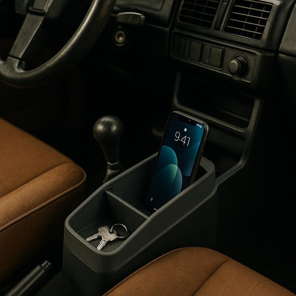 Mobiltelefon og bilnøgler i en bils midterkonsol.