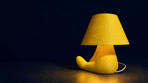 Gul Loopy Shy-lampe på mørk navy baggrund