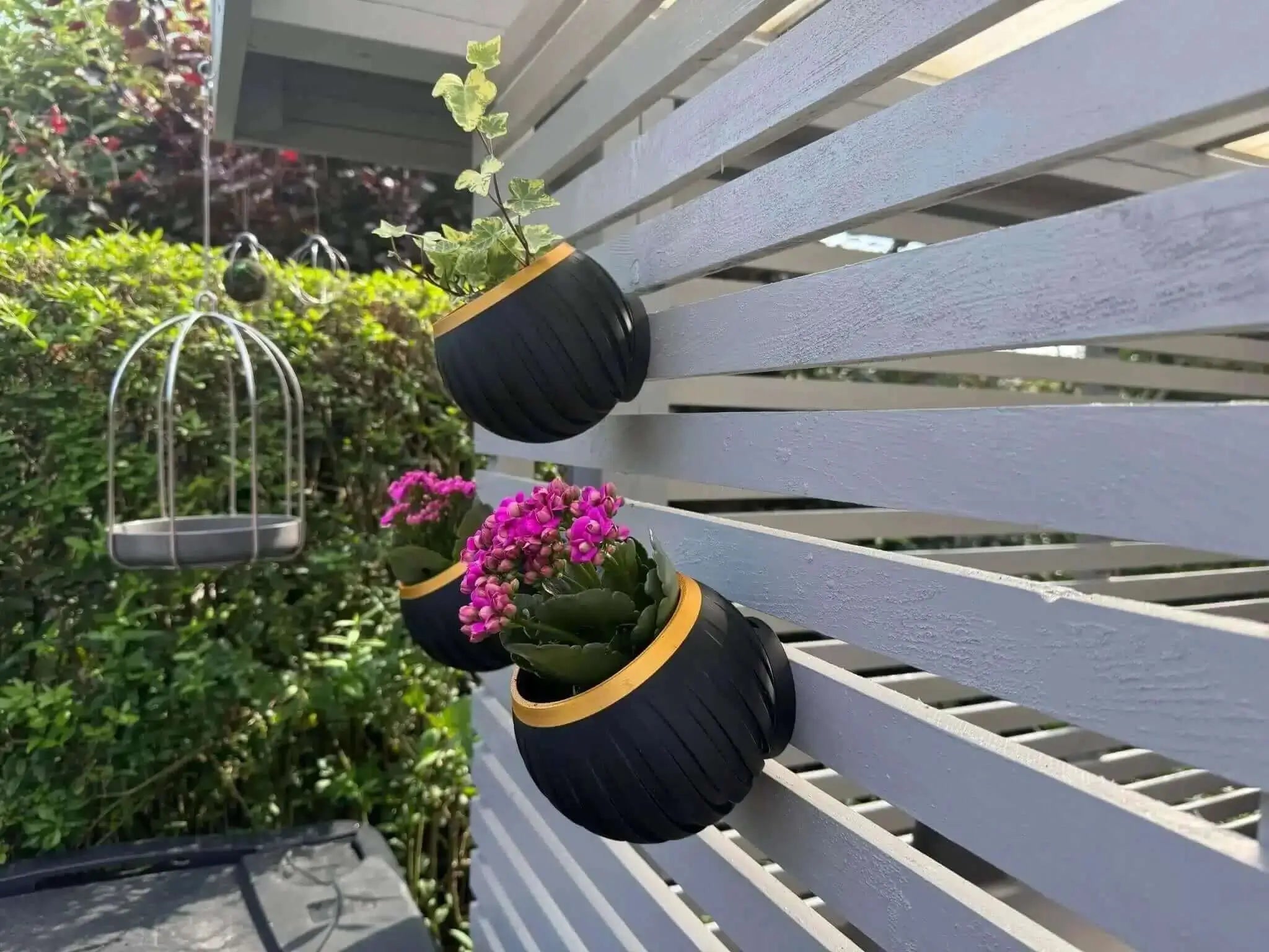 "Kadla væghængt vase i sort og guld – elegant plantekrukke til stilfuld vægdekoration fra JM Dimensions"