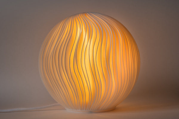 Leora O5 Wind Skulpturlampe, tændt, med bugtede ribber i overfladen