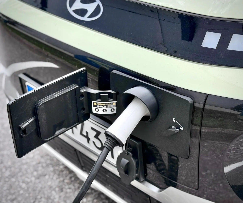 Hyundai Inster Ladeport Cover monteret med tilsluttet Type 2-ladestik og låsehåndtag